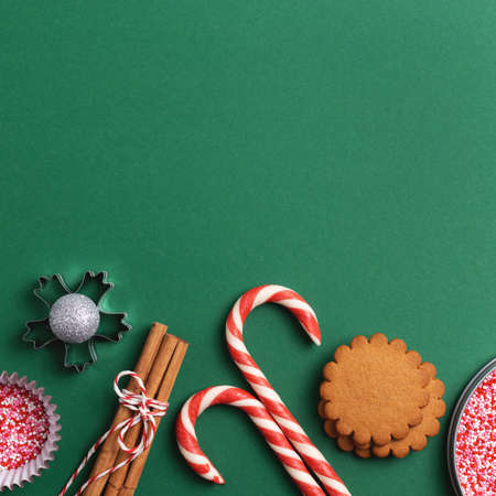 Christmas holiday green square background with empty space. Cookies, sweets, cupcake sprinkles from above.の写真素材