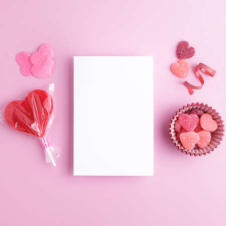 Square Valentines day layout with blank card and holiday romantic decorations on pastel pink...