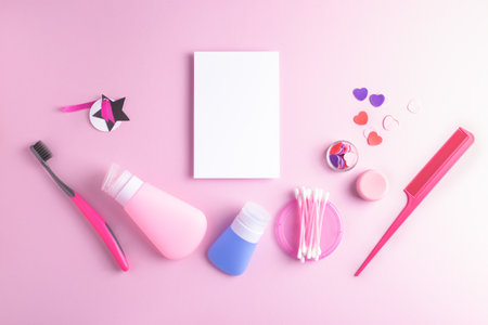 Girly flatlay with white notebook page and daily self care cosmetics arranged on pink background. Top view, copy space.の写真素材