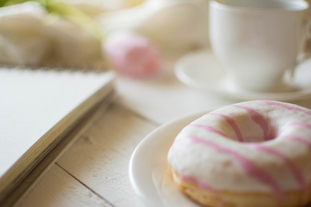 Tender pink vintage background. Tulip, notebook, coffee cup and donut. Confession of love.の写真素材