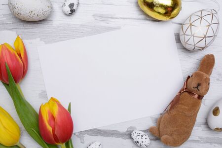 Easter eggs and tulips over wooden background.の写真素材