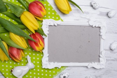 Easter eggs and tulips over wooden background.の写真素材