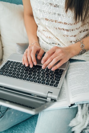 Beautiful girl is typing on a laptop.の写真素材