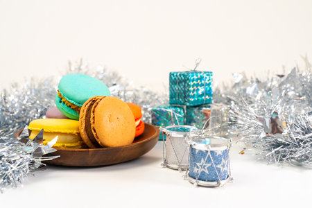 Multicolored French cookies in a white plate on a tinsel background.の写真素材