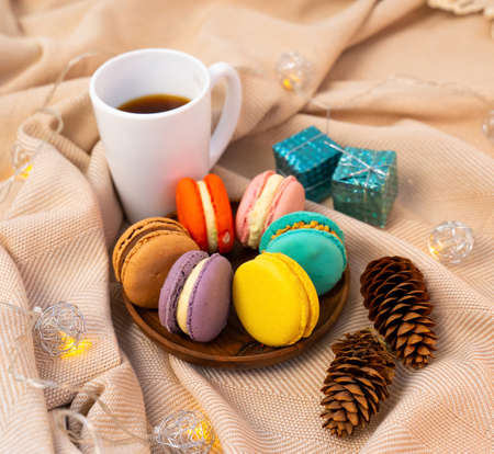 French pastries on a wooden bowl. A cup of tea. Macaroon composition.の写真素材