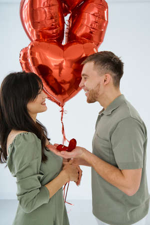 Man makes present to his lovely sweetheart girl. Lovers valentine day. The guy gives his girlfriend a piece of jewelry. Wedding ring. Happy smile girl.の写真素材