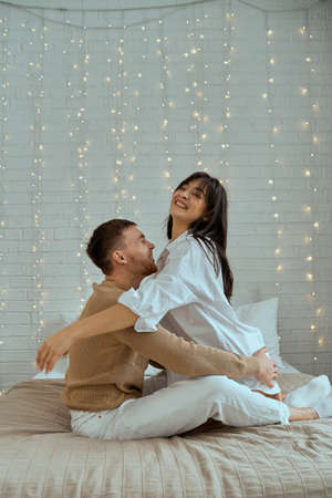 The guy and the girl are hugging on the bed.の写真素材