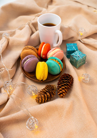 French pastries on a wooden bowl. A cup of tea. Macaroon composition.の写真素材