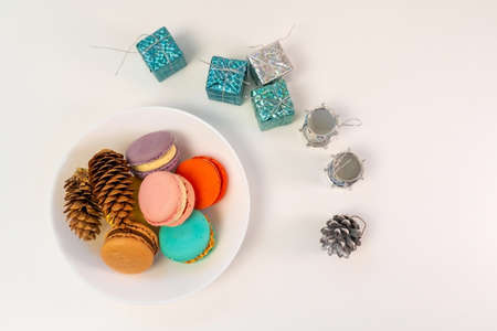 Multicolored French cookies in a white plate on a tinsel background. top viewの写真素材