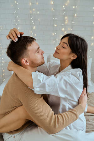 The guy and the girl are hugging on the bed.の写真素材