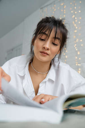 Portrait of a happy beautiful woman reading a book, enjoying her vacation. Young female student...