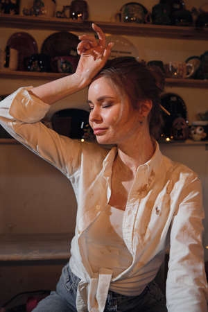 Portrait of a beautiful girl in a pottery workshop.の写真素材