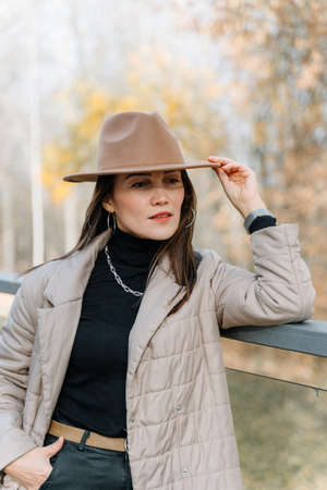 Autumn portrait of a girl in a beige coat and hat.の写真素材