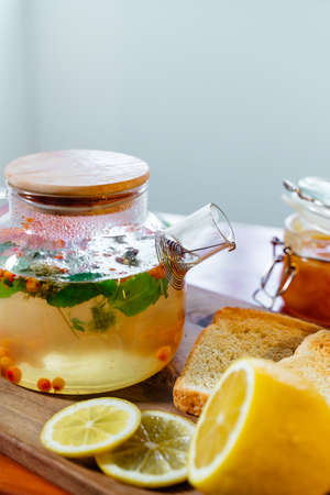 Beautiful glass teapot with sea buckthorn tea. Hot winter drinksの写真素材