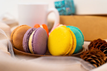 French pastries on a wooden bowl. A cup of tea. Macaroon composition.の写真素材