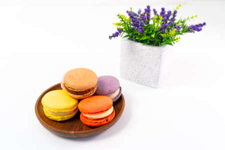 Multicolored macarons on a wooden plate on a white background.の写真素材