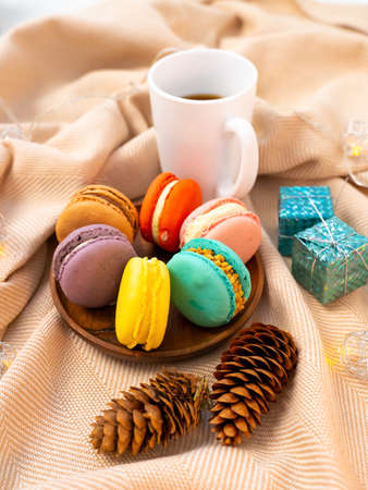 French pastries on a wooden bowl. A cup of tea. Macaroon composition.の写真素材