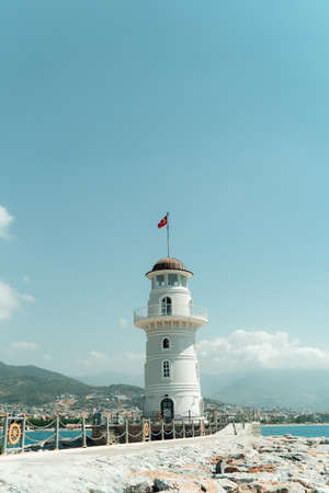 Lighthouse in the port of Alanya. white lighthouse in seaport of Alanya with concrete path and stonesの写真素材