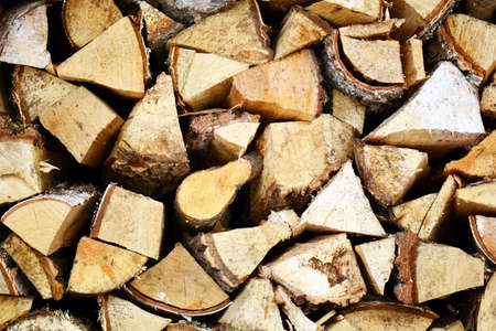 Natural wooden background, closeup of chopped firewood. Firewood stacked and prepared for winter...