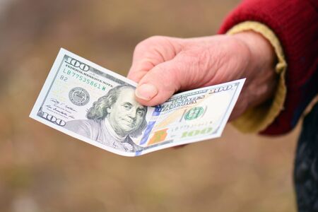The old lady is holding money in her handの写真素材