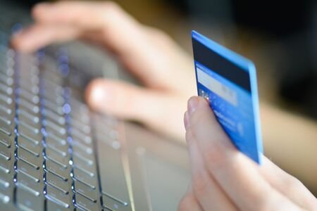 woman holding credit card on laptop for online shopping concept.