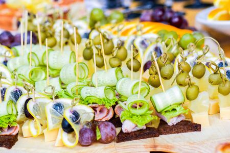 Beautifully decorated catering banquet table with different food snacks and appetizers on corporate christmas birthday party event or wedding celebrationの写真素材