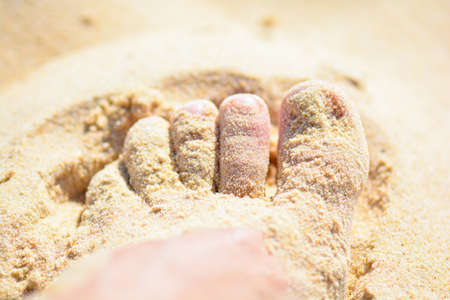 foot in the sand on the beachの写真素材