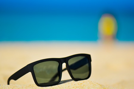 Fashion sunglasses on sea beach. Summer holiday relax background with copy spaceの写真素材