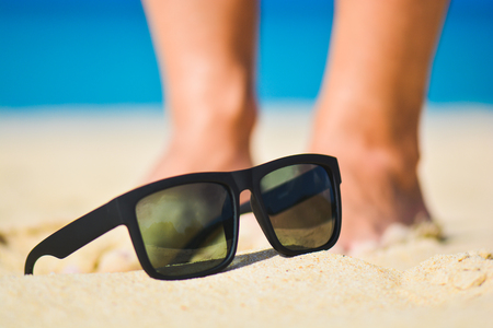 Fashion sunglasses on sea beach. Summer holiday relax background with copy spaceの写真素材