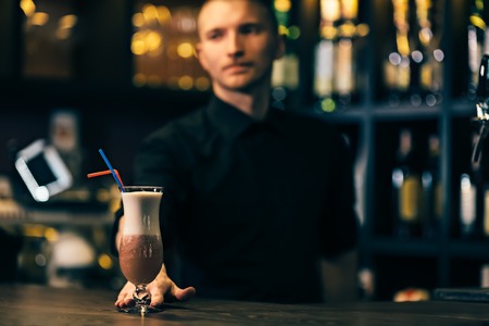 Cocktail is on the bar counter. Bartender is on backgroundの写真素材