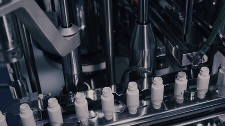 Drug Production. Medical vials on pharmaceutical manufacturing line. Medical ampoules on automated...
