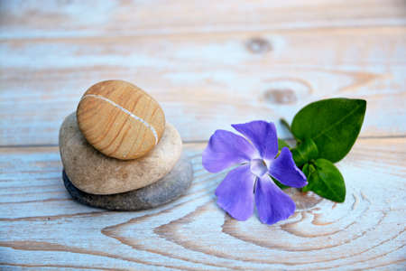 Three zen stones on old wood decoratedith purple flowersの写真素材