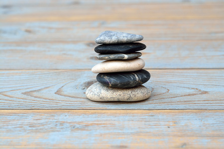 crain gray black zen stones on gray, blue, knotted old wooden shelves background with emty copyspaceの写真素材