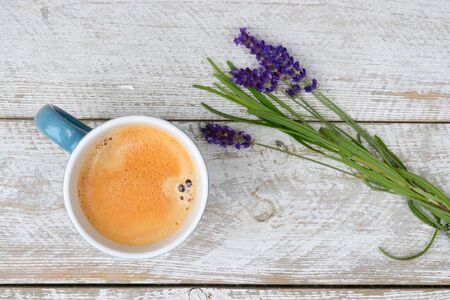 Blue coffee cup and lavender on a old white wooden shelves background with empty copyspace with embroidery napkin in vintage styleの写真素材