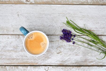 Blue coffee cup and lavender on a old white wooden shelves background with empty copyspaceの写真素材