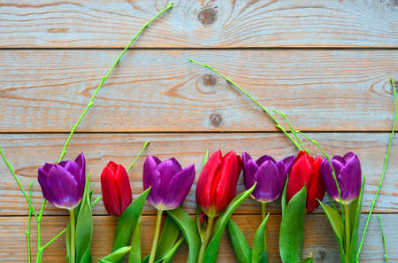 A bouquet of purple red tulips on a wooden empty copy space backgroundの写真素材