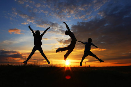 Three friends jumping at sunset, freedom concept.の写真素材