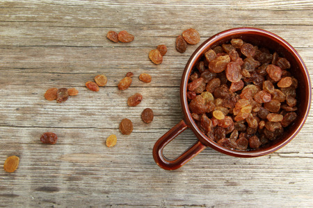 Raisins in the bowl on the wooden tableの写真素材