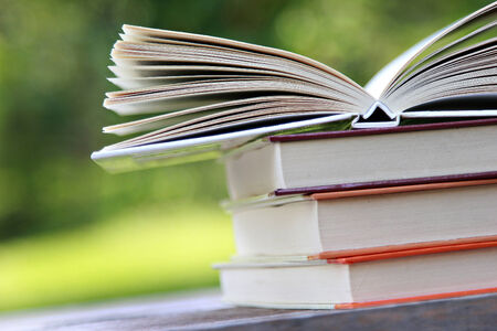 Pile of books on the table with open ones