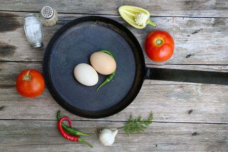 Ready for breakfast, Pan with raw eggs and vegetablesの写真素材