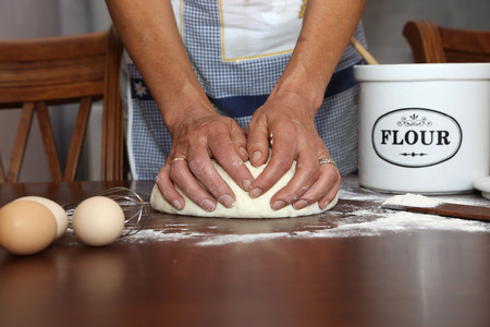Making Dough, Woman hands kneading dough on the table