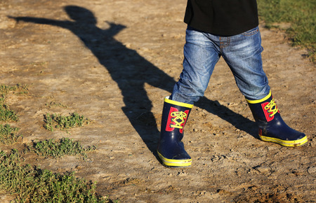 Shadow of kid in the rubber bootsの写真素材