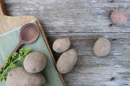 Organic potatoes on an old wooden tableの写真素材
