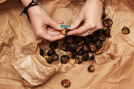 Roasted chestnuts on wrinkled brown paperの写真素材