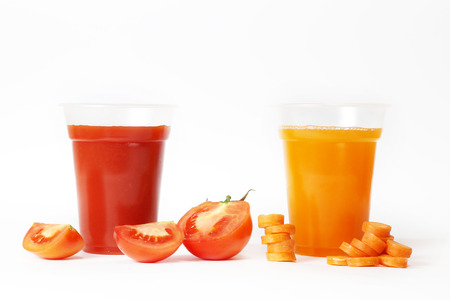 Two glasses full of tomato and carrot juice on whiteの写真素材