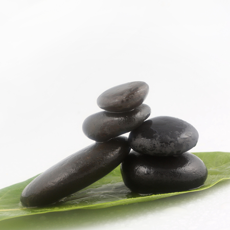 Balanced black zen stones on white backgroundの写真素材