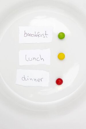 Diet concept, Green for breakfast, yellow for lunch and red for dinner, diet concept in the plateの写真素材