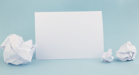 Creative process - crumpled and wrinkled paper wads with fresh sheet of blank paperの写真素材