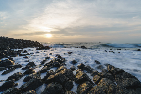 Waves crashing over rocks in Zhangzhou Volcano National Geopark at sunrise
