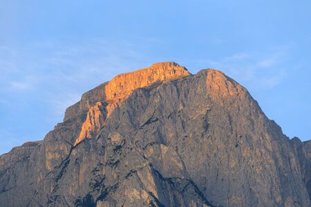 Rugged mountain peaks against blue sky, with alpenglow